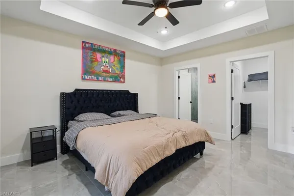 a bedroom with a large bed and a chandelier