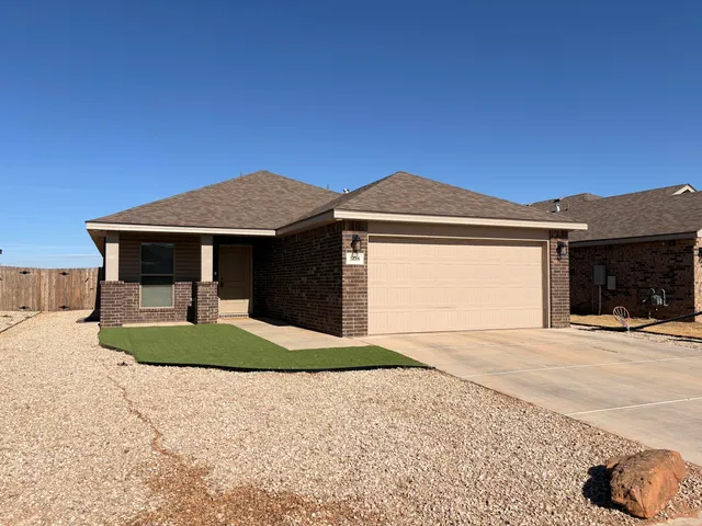 a front view of a house with a garden and yard