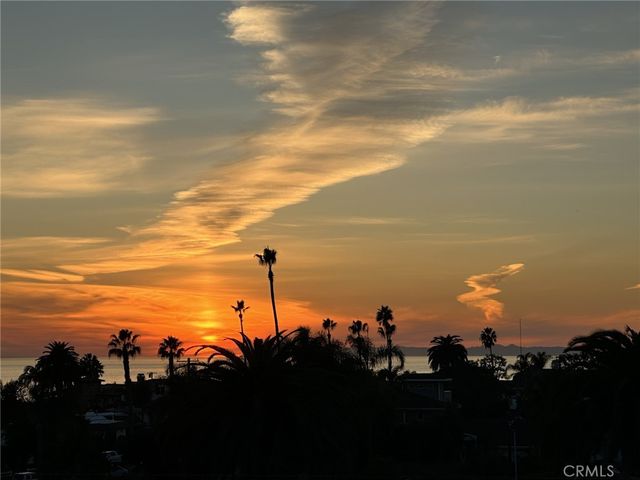a view of a hallway with wooden floor and cabinet