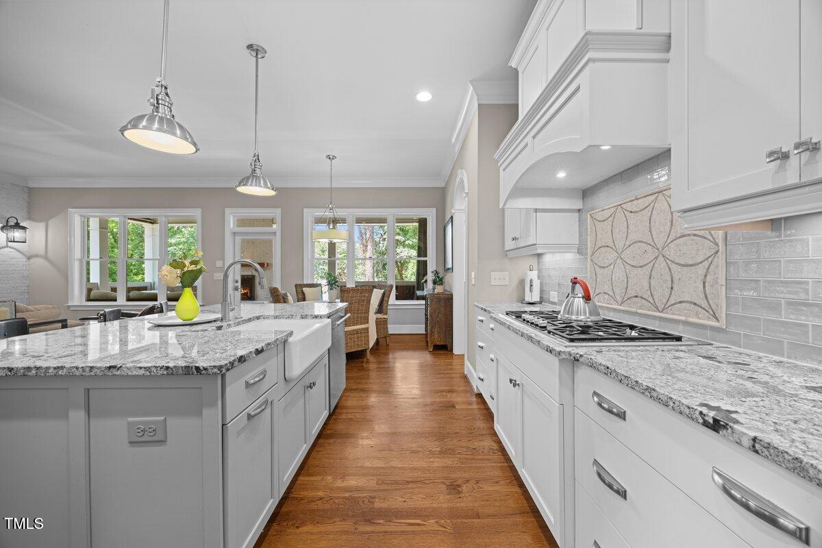 3034 Lewis Farm Road Raleigh, NC 27607 - Photo 15 of 60 a large kitchen with kitchen island a large counter space a sink appliances and a view of living room