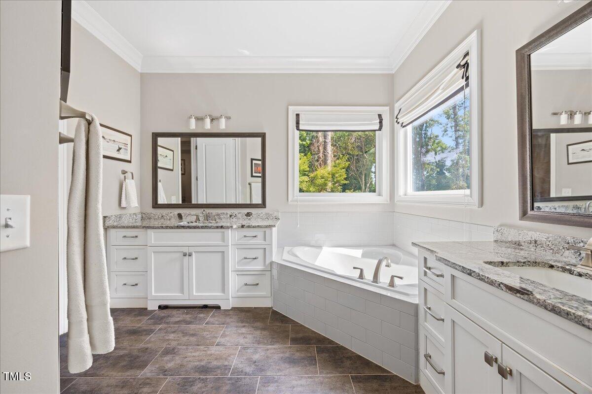3034 Lewis Farm Road Raleigh, NC 27607 - Photo 28 of 60 a bathroom with a granite countertop tub sink and mirror