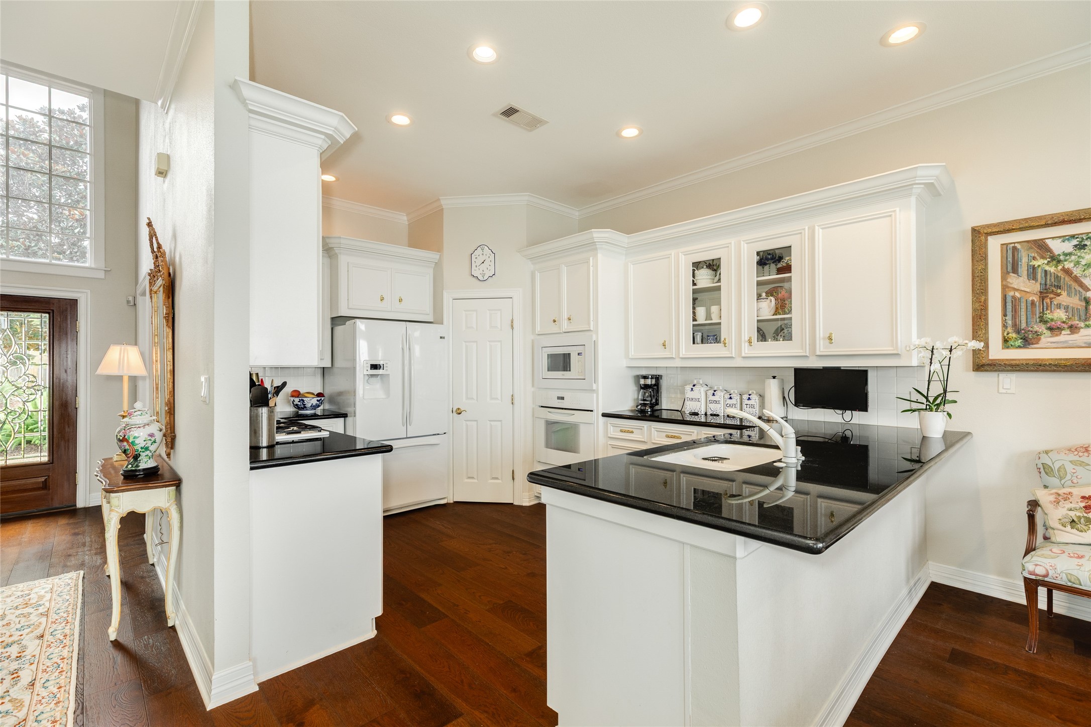 7306 Offats Point Circle Galveston, TX 77551 - Photo 32 of 50 a kitchen with stainless steel appliances granite countertop a refrigerator a stove and white cabinets with wooden floor
