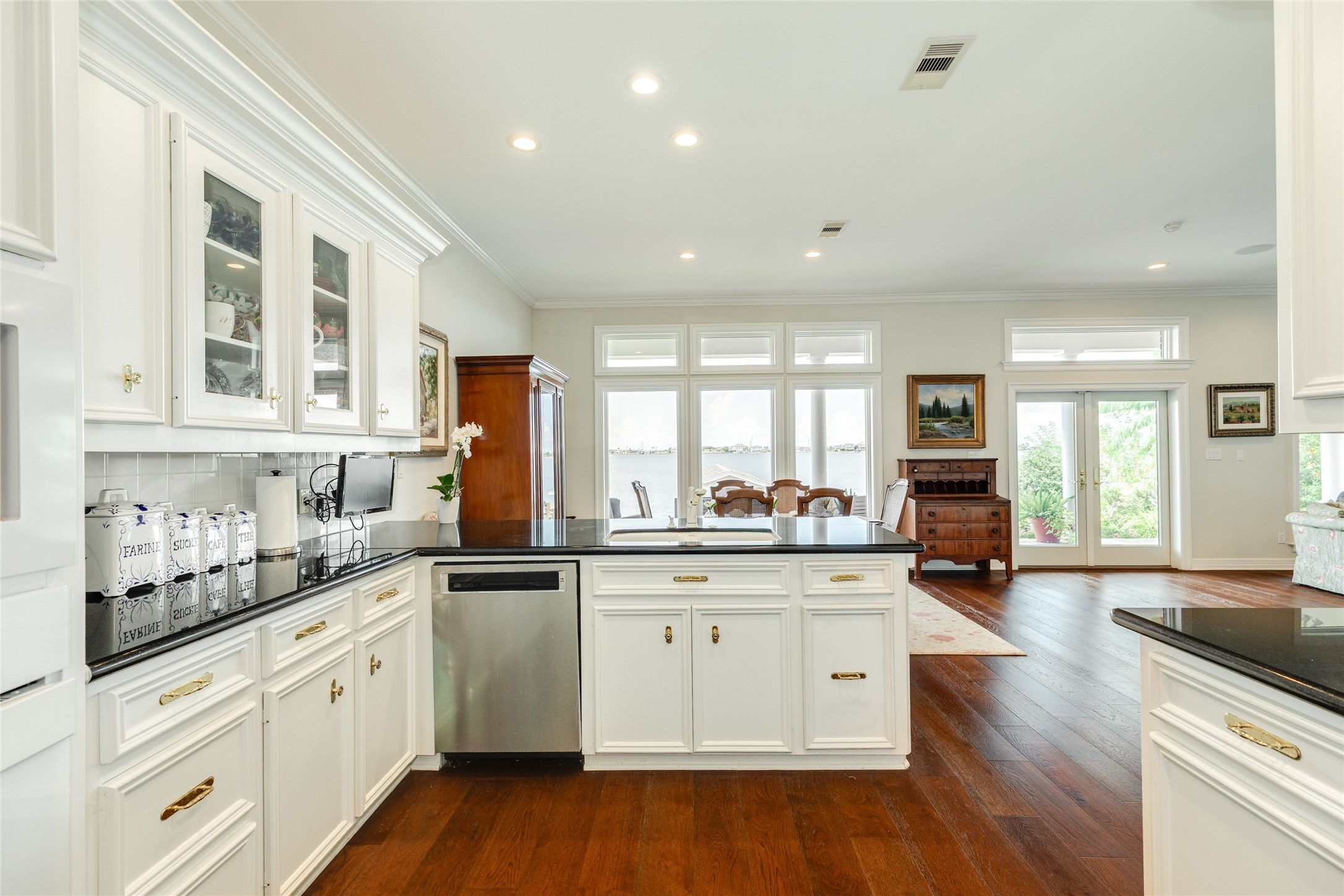 7306 Offats Point Circle Galveston, TX 77551 - Photo 34 of 50 a kitchen with stainless steel appliances white cabinets and wooden floor