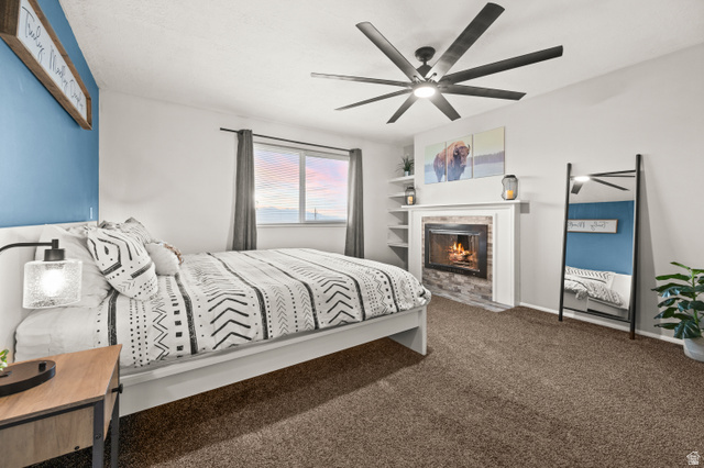 9750 Indian Ridge Drive Sandy, UT 84092 - Photo 20 of 40 Bedroom with carpet, a ceiling fan, and a fireplace