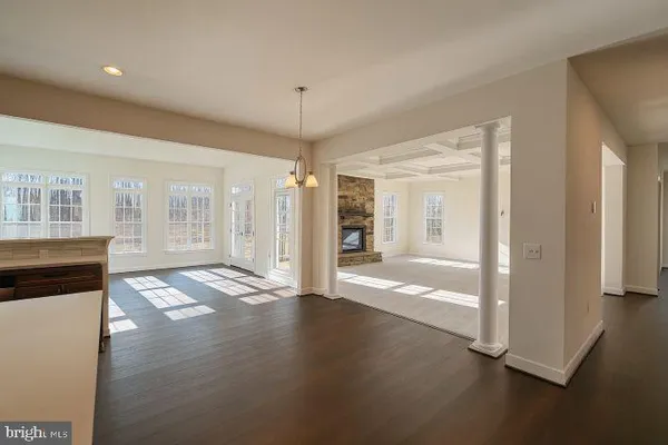 a view of a hallway with wooden floor and a living room