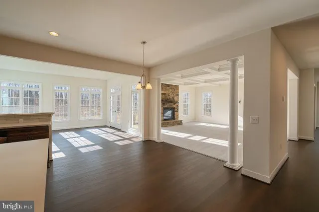 a view of a hallway with wooden floor and a living room