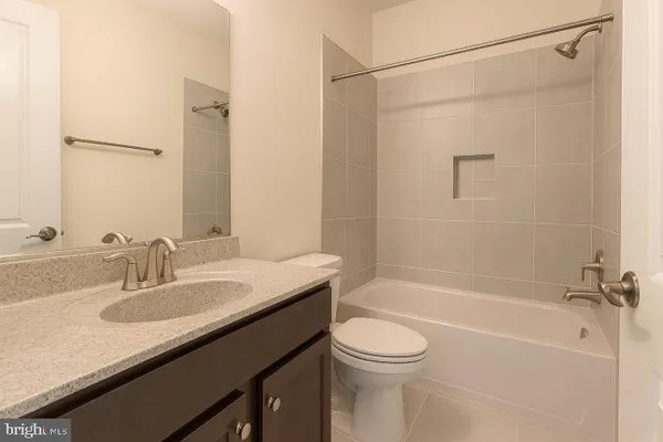 a bathroom with a granite countertop sink a toilet and shower