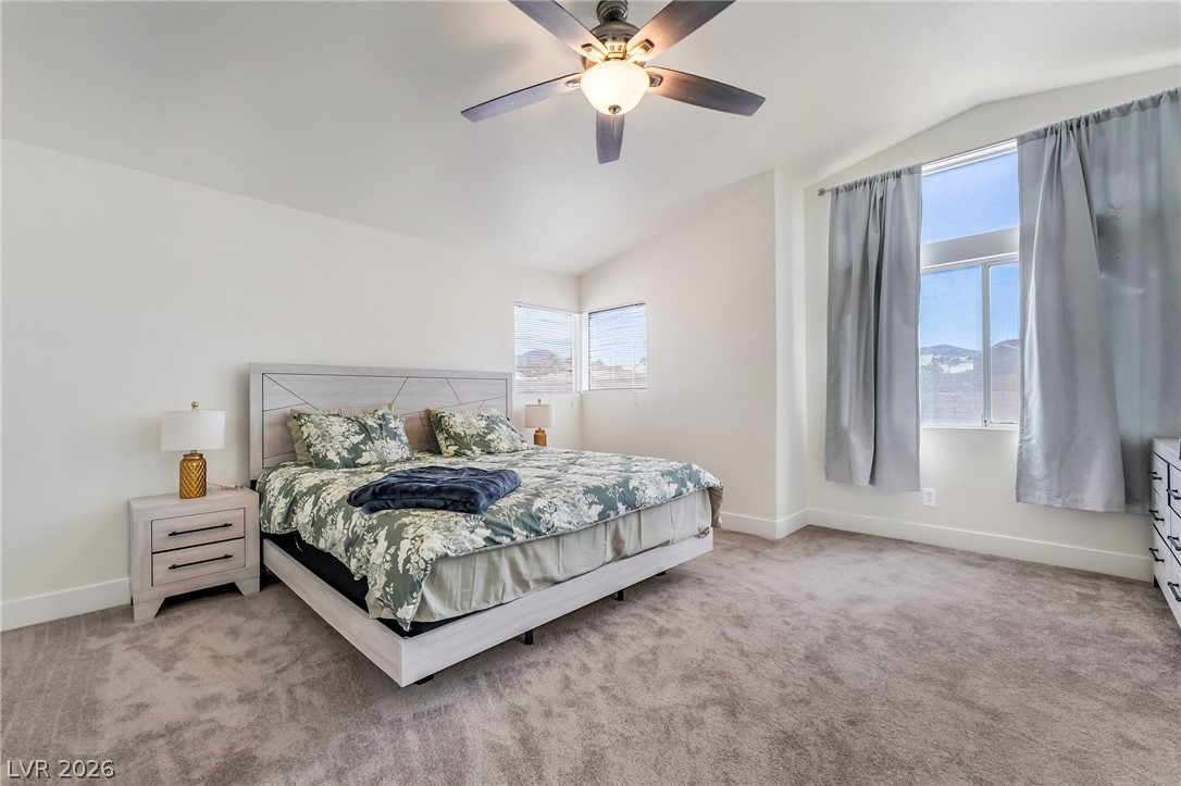 104 Appian Way Henderson, NV 89002 - Photo 15 of 24 A spacious sleeping area with vaulted ceilings, featuring a contemporary ceiling fan and well-lit windows.