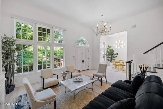 a living room with furniture a chandelier and a window