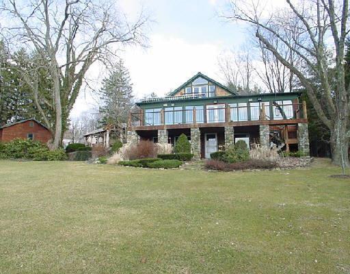 a front view of a house with a garden and trees