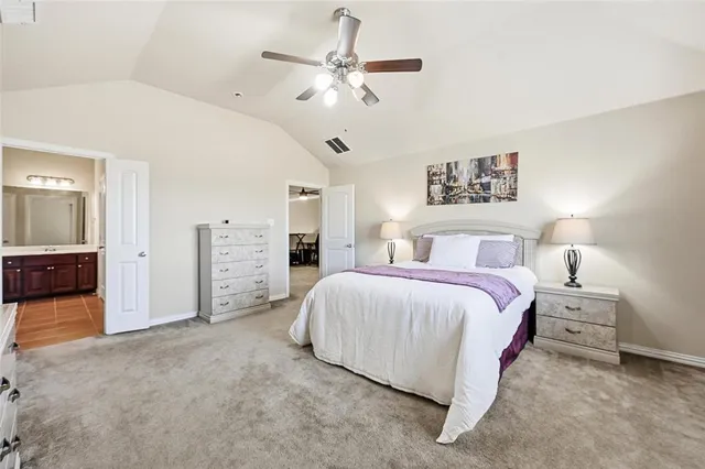 a bedroom with a bed a chandelier and dresser