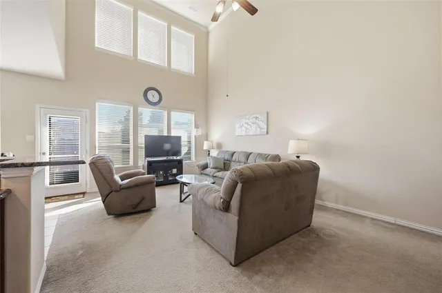a living room with furniture and a ceiling fan