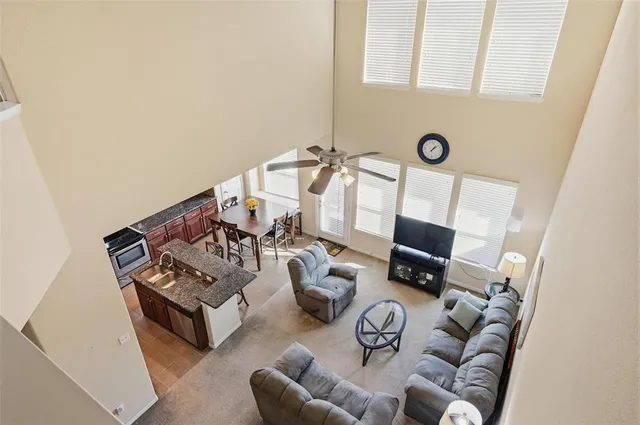 a kitchen with granite countertop a sink a counter top space and living room view