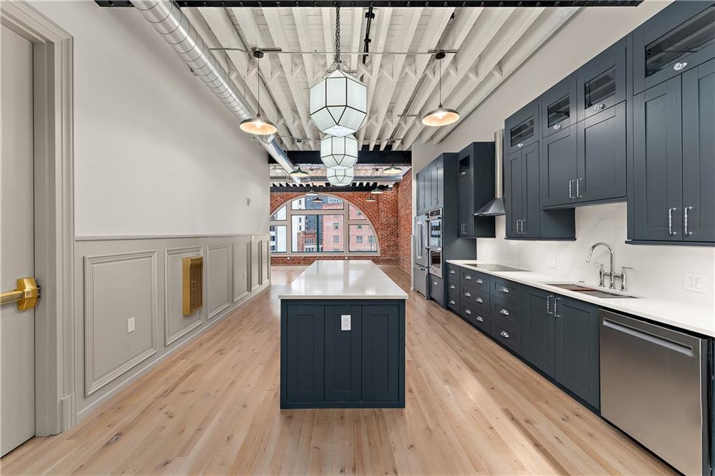 915 Liberty Avenue, Unit 701 Pittsburgh, PA 15222 - Photo 12 of 50 a kitchen with stainless steel appliances granite countertop a sink a stove and a wooden floors