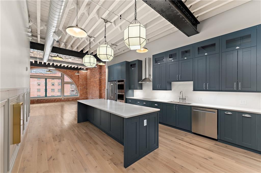 915 Liberty Avenue, Unit 701 Pittsburgh, PA 15222 - Photo 13 of 50 a kitchen with stainless steel appliances granite countertop a sink a stove and a wooden floors