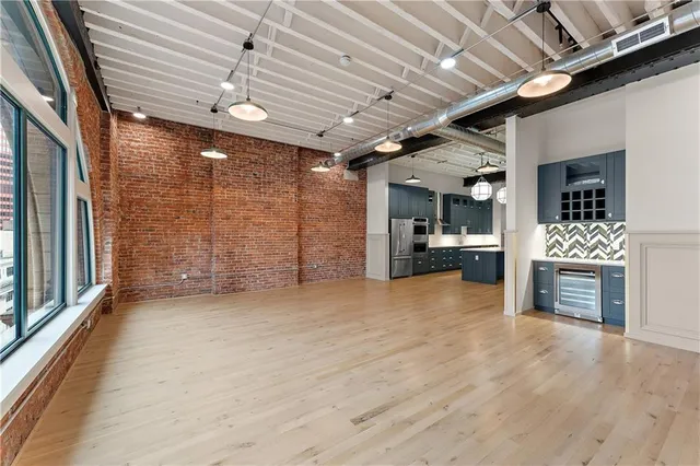 a view of a kitchen with an empty space and wooden cabinet