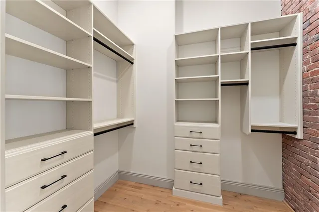 a view of walk in closet with empty racks