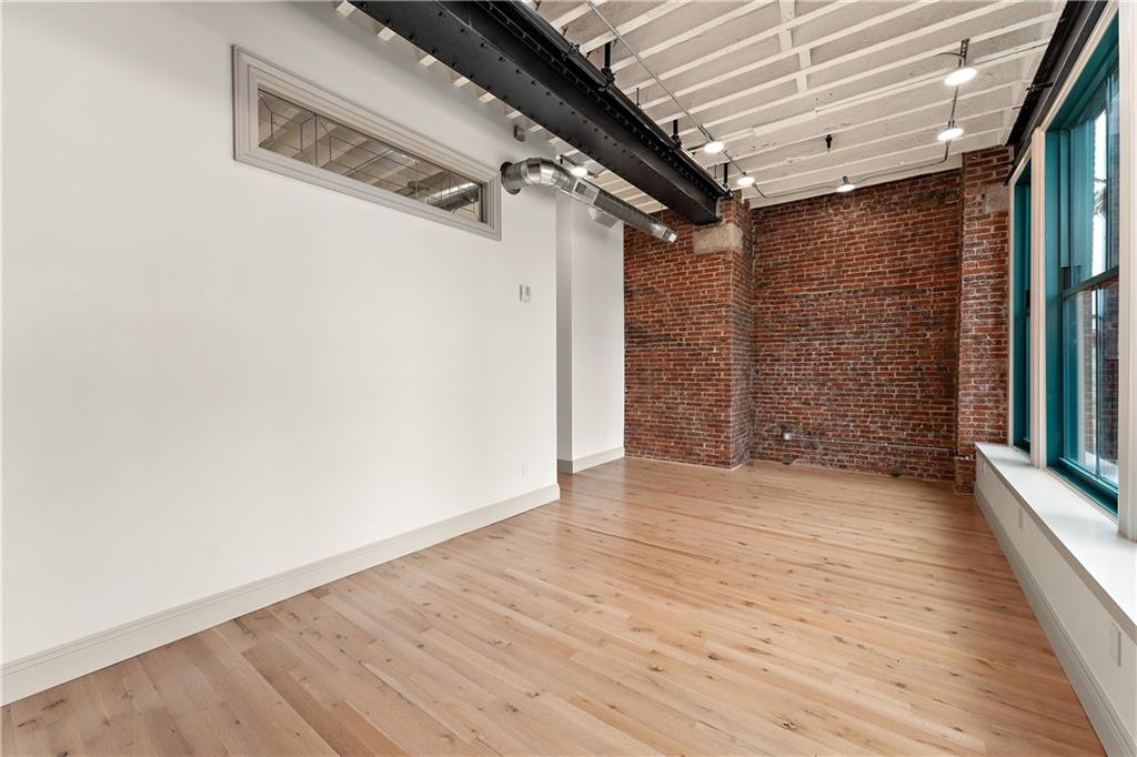 915 Liberty Avenue, Unit 701 Pittsburgh, PA 15222 - Photo 47 of 50 an empty room with wooden floor and windows