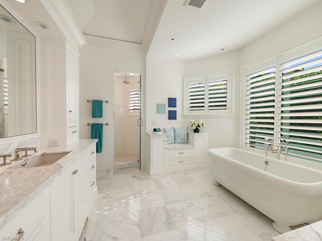 3630 Rum Row Naples, FL 34102 - Photo 12 of 28 a bathroom with a granite countertop tub a sink and a large mirror