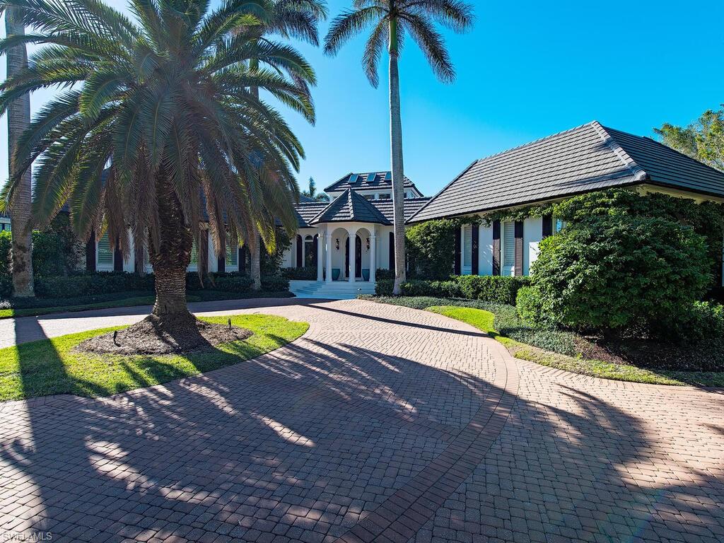 3630 Rum Row Naples, FL 34102 - Photo 2 of 28 a view of swimming pool with lawn chairs under an umbrella