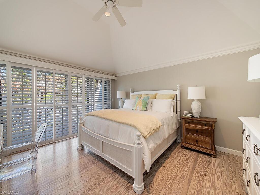 3630 Rum Row Naples, FL 34102 - Photo 24 of 28 a bedroom with a bed and a lamp on the dresser