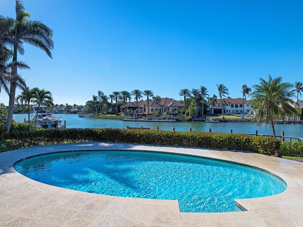 3630 Rum Row Naples, FL 34102 - Photo 25 of 28 a view of a swimming pool and a yard