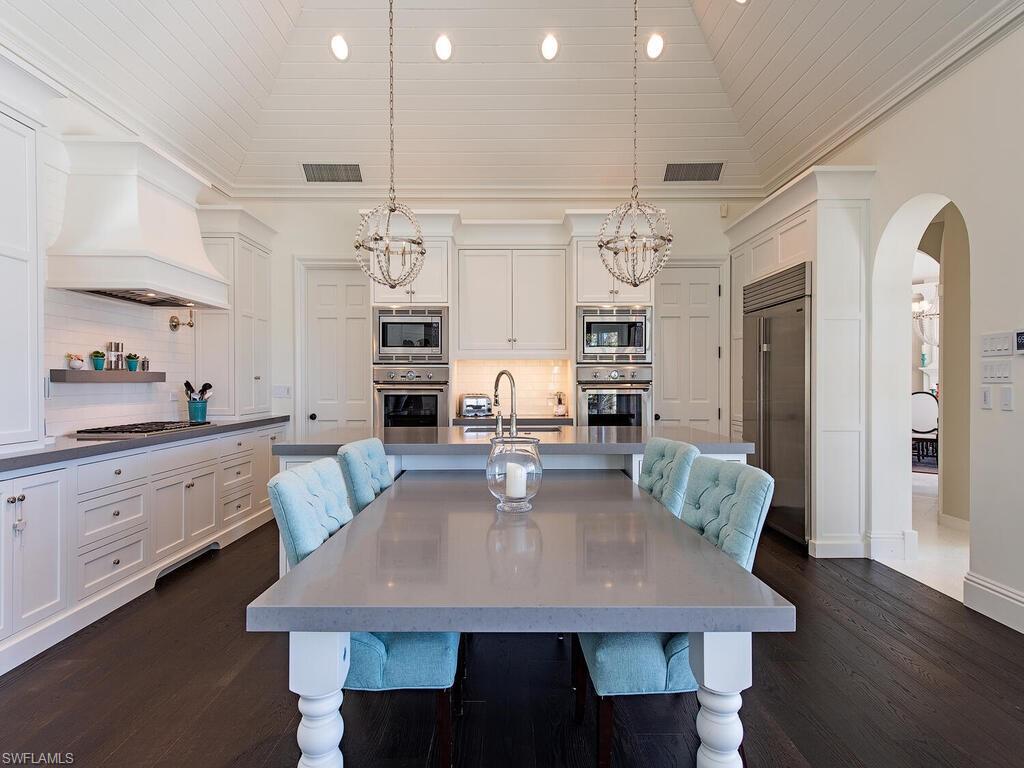 3630 Rum Row Naples, FL 34102 - Photo 5 of 28 a view of a dining room with furniture a chandelier and wooden floor