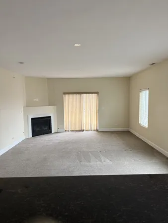 an empty room with a fireplace and a window