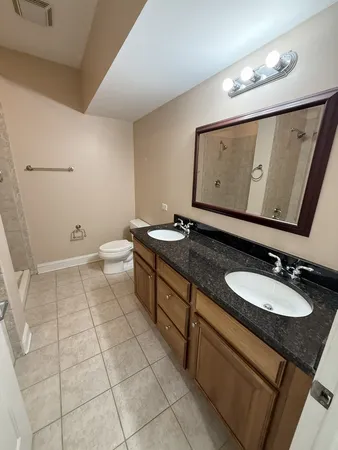 a bathroom with a granite countertop sink a mirror and toilet