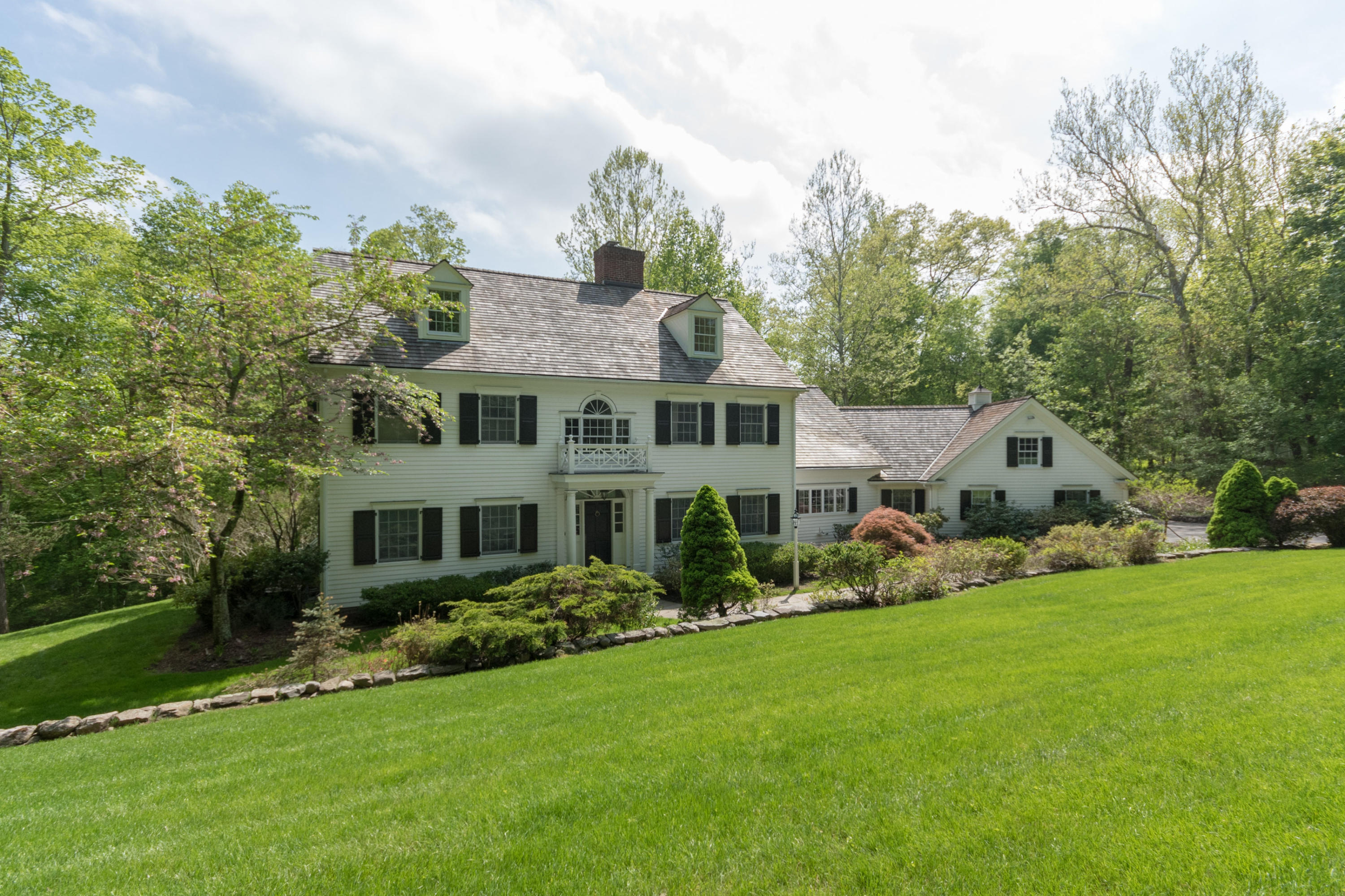 123 Lone Tree Farm Road New Canaan, CT 06840 - Photo 20 of 26 a front view of a house with a yard and trees