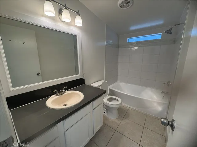 an empty room with windows and ceiling fan