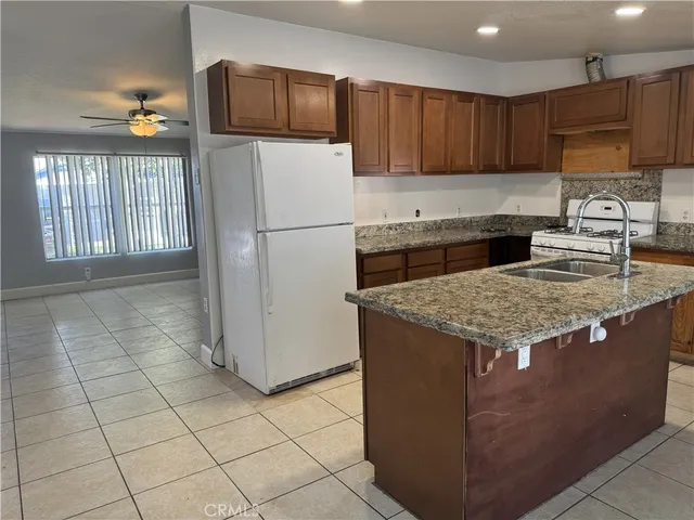 a kitchen with stainless steel appliances granite countertop a refrigerator and a stove top oven