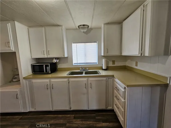 a utility room with kitchen island a stove a sink and a microwave