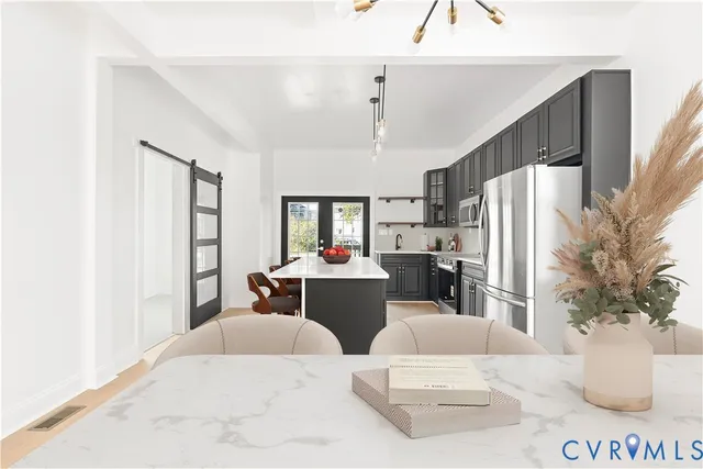 a living room with furniture and a refrigerator