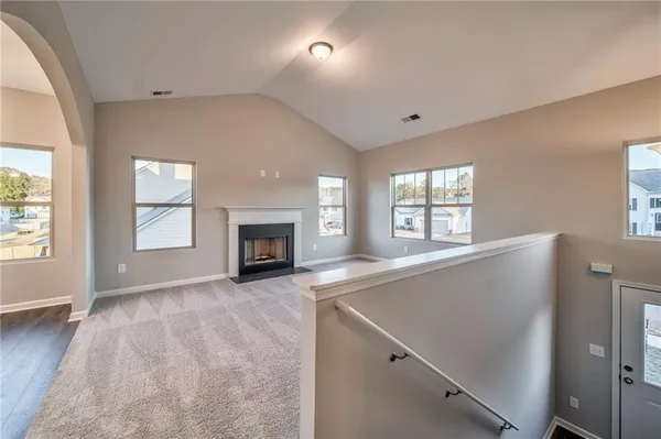 a view of an empty room with a window and fireplace