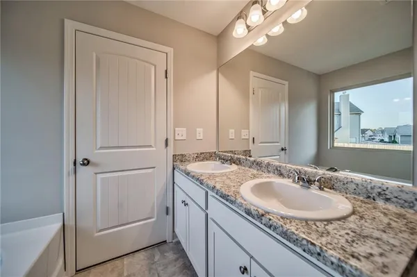 a bathroom with a granite countertop sink a mirror and a vanity