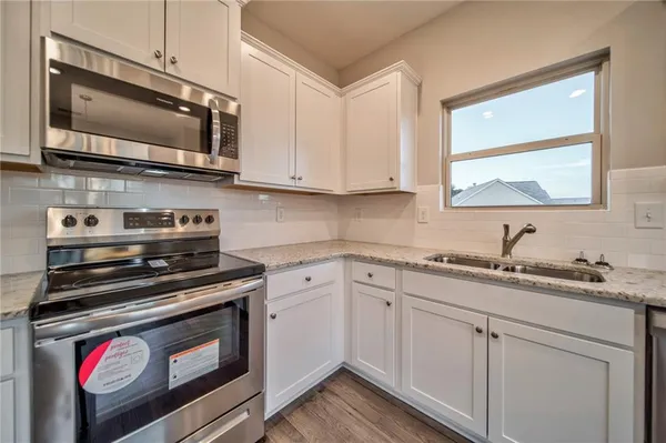 a kitchen with stainless steel appliances granite countertop a sink stove and microwave
