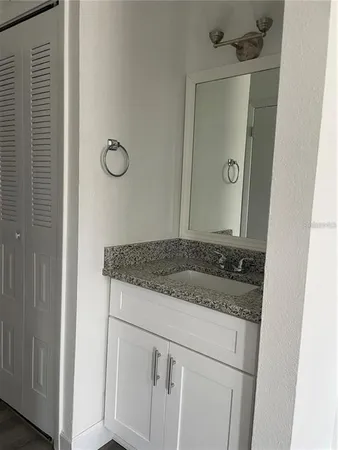 a bathroom with a granite countertop sink and mirror