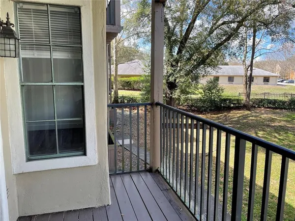 a view of balcony with wooden floor and fence