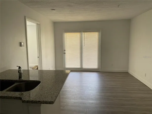 a view of a sink and cabinets in wooden floor