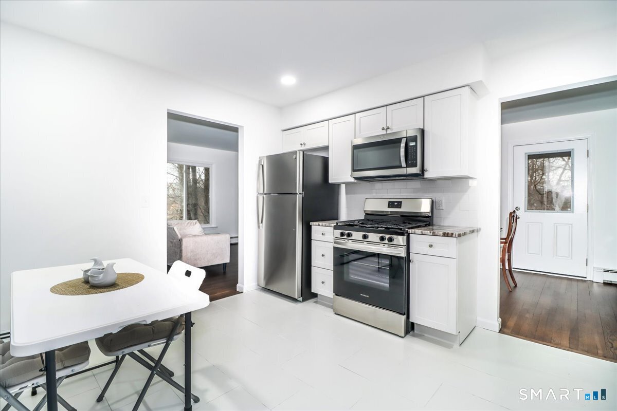 33 Hickory Hill Road Brookfield, CT 06804 - Photo 12 of 35 a kitchen with stainless steel appliances kitchen island granite countertop a sink refrigerator and microwave
