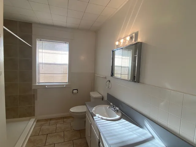 a bathroom with a sink a toilet and mirror