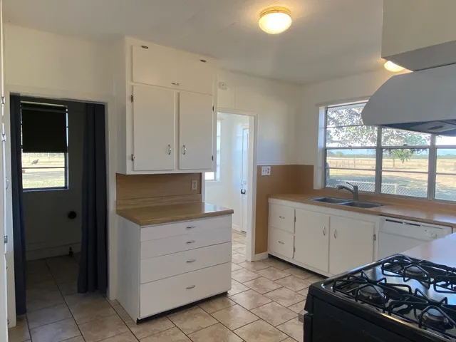 a kitchen with sink stove and cabinets