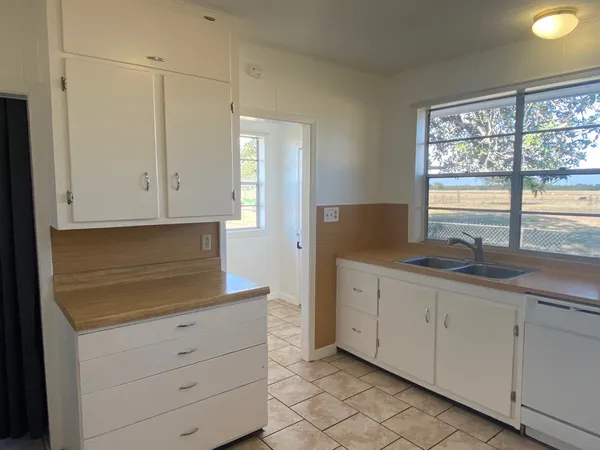 a kitchen with granite countertop white cabinets and sink