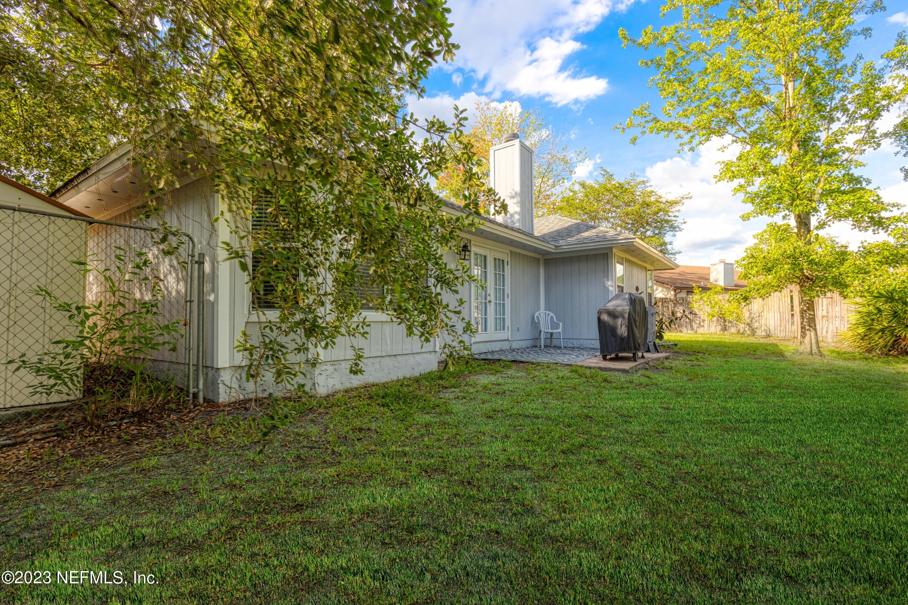 9698 Pritmore Road East Jacksonville, FL 32257 - Photo 23 of 28 a view of a yard with plants and a large tree