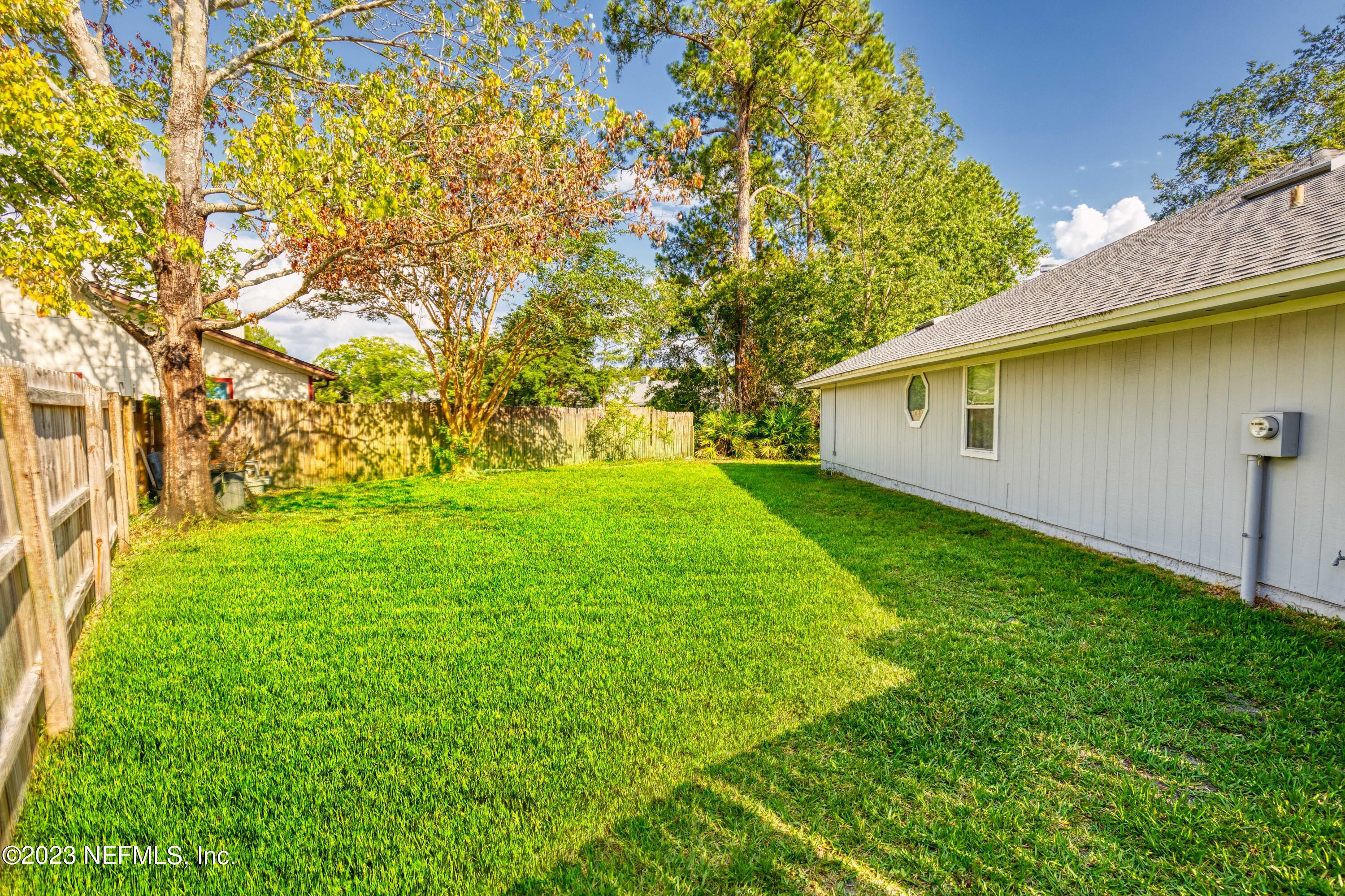 9698 Pritmore Road East Jacksonville, FL 32257 - Photo 24 of 28 a backyard of a house with plants and large trees