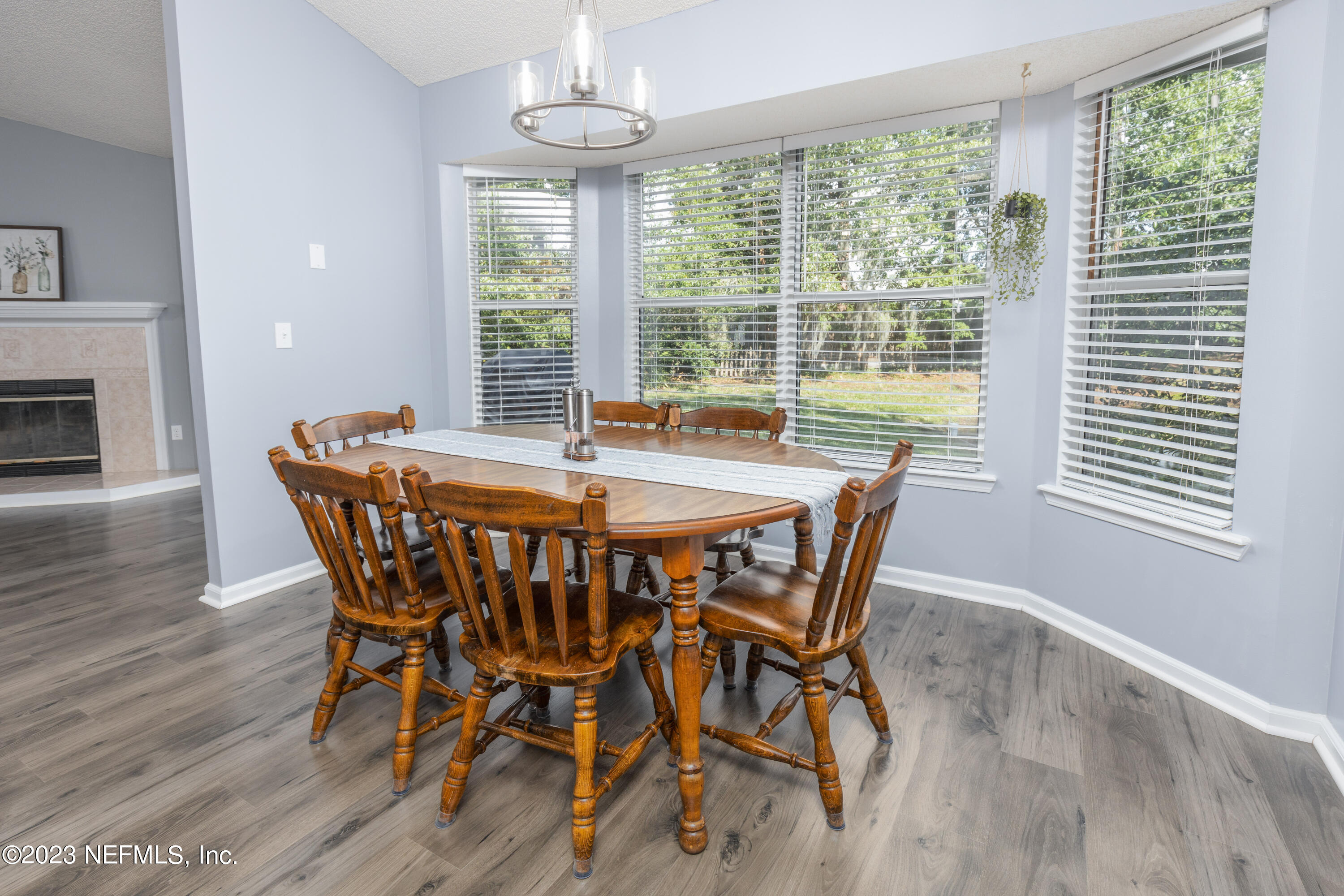 9698 Pritmore Road East Jacksonville, FL 32257 - Photo 6 of 28 a dining room with furniture a chandelier and wooden floor