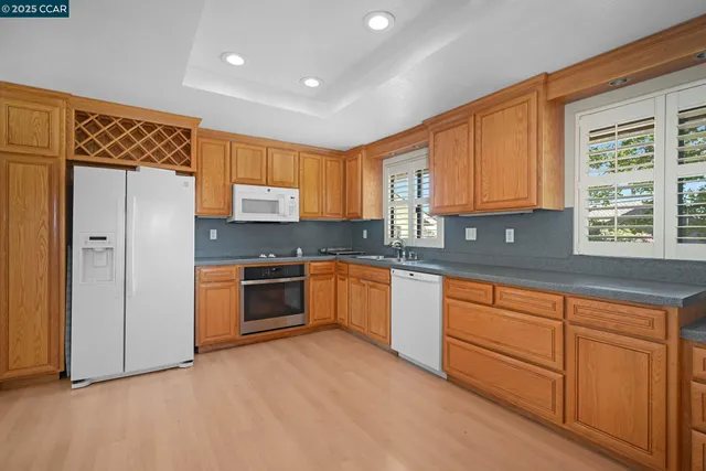 a kitchen with stainless steel appliances granite countertop a stove a sink and a refrigerator