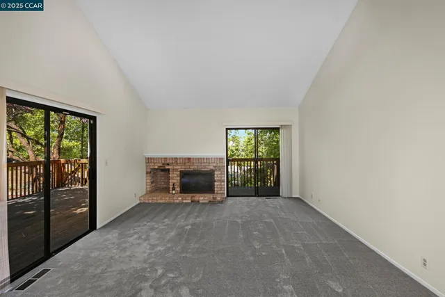 a view of an empty room with a fireplace and a window