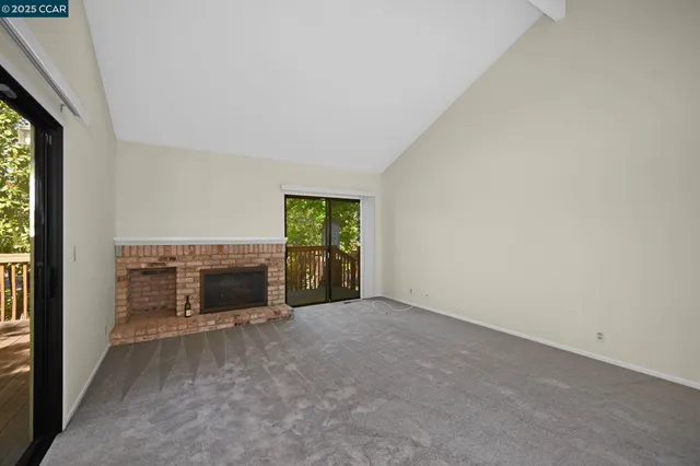 a view of an empty room with a fireplace and a window